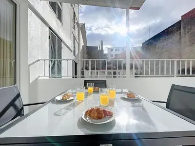 a table with food and glasses of orange juice on a balcony at CityZen Funchal by Atlantic Holiday in Funchal