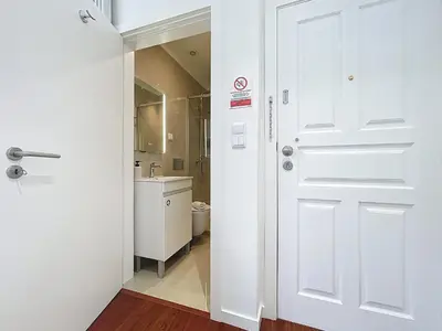 a bathroom with a white door and a sink at CityZen Funchal by Atlantic Holiday in Funchal
