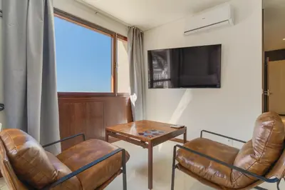 a living room with two chairs and a table and a tv at Urso Tigre Apartment by Holiday Rental Madeira in Funchal