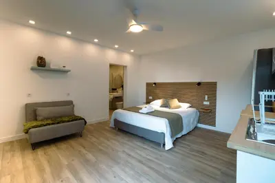a bedroom with a bed and a chair at Casa do Faiska in Câmara de Lobos