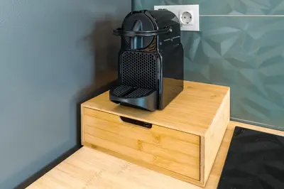a black coffee maker sitting on top of a wooden stand at Casa do Faiska in Câmara de Lobos