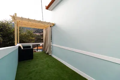 an outdoor balcony with green grass at Casa do Faiska in Câmara de Lobos