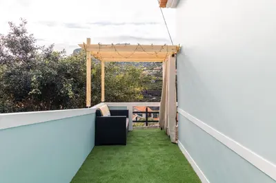 a balcony with green grass and a pergola at Casa do Faiska in Câmara de Lobos