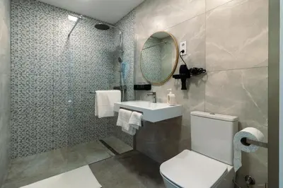 a bathroom with a toilet and a sink and a mirror at Casa do Faiska in Câmara de Lobos