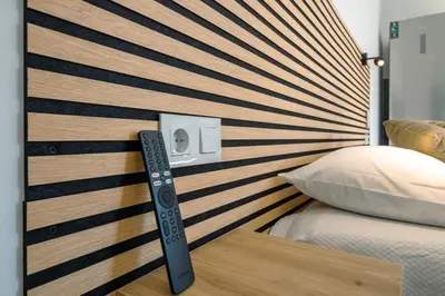a bed with a wooden headboard with a remote control at Casa do Faiska in Câmara de Lobos