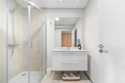a white bathroom with a sink and a shower at Atlantic View by An Island Apart in Funchal