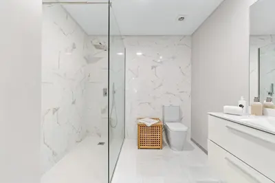a white bathroom with a shower and a toilet at Atlantic View by An Island Apart in Funchal