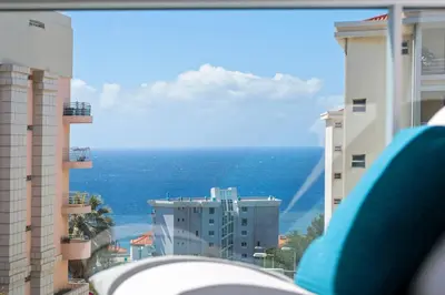 a view of the ocean from between buildings at Atlantic View by An Island Apart in Funchal