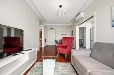 a living room with a couch and red chairs at SeaSide Serenity in Funchal