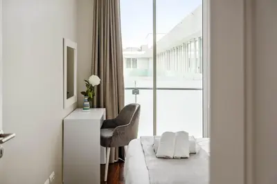 a hotel room with a bed and a chair and a window at SeaSide Serenity in Funchal