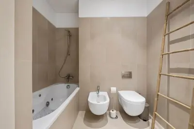 a bathroom with a tub and a toilet and a sink at SeaSide Serenity in Funchal