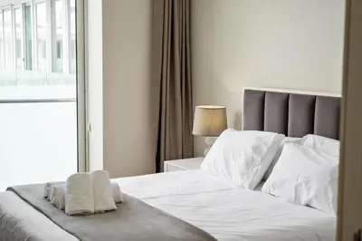 a bedroom with a white bed with a window at SeaSide Serenity in Funchal