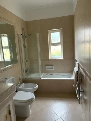a bathroom with a tub and a toilet and a sink at Fairviews Boavista , Boavista golf and spa resort Lagos in Lagos