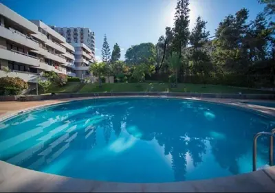 a large blue swimming pool in front of a building at Carlos Apartment by Holiday Rental Madeira in Funchal