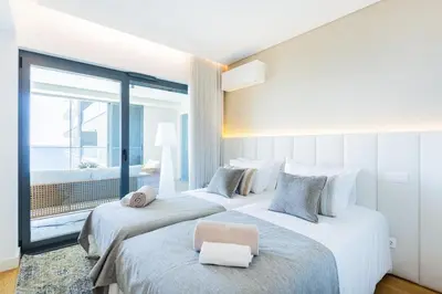 two beds in a hotel room with a large window at Satoshi Ocean View in Funchal