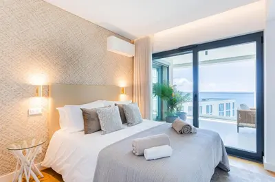 a bedroom with a large bed and a large window at Satoshi Ocean View in Funchal