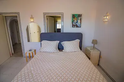 a bed with a blue headboard in a bedroom at Apartamento Casa do Mar Praia da Luz in Luz