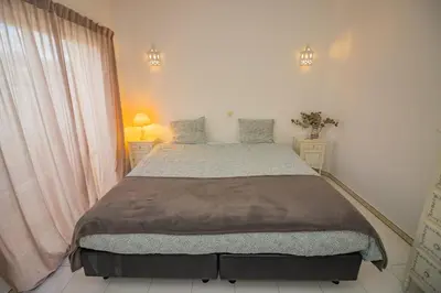 a bedroom with a large bed and two night stands at Apartamento Casa do Mar Praia da Luz in Luz
