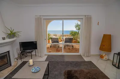 a living room with a fireplace and a view of the ocean at Apartamento Casa do Mar Praia da Luz in Luz