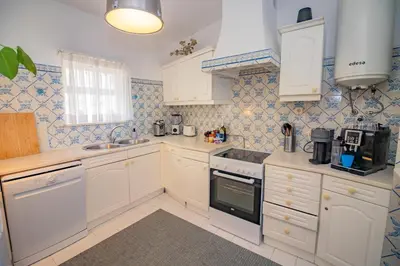 a kitchen with white appliances and blue tiles at Apartamento Casa do Mar Praia da Luz in Luz