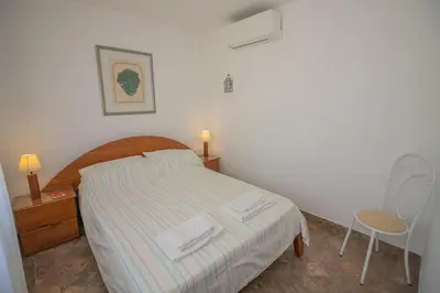 a bedroom with a bed and a table and a chair at Casa dos Sonhos Praia da Luz in Luz