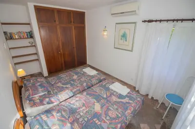a bedroom with a bed and a wooden cabinet at Casa dos Sonhos Praia da Luz in Luz