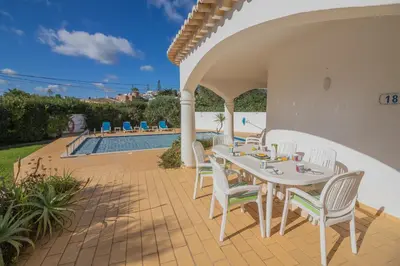 a patio with a table and chairs and a pool at Casa dos Sonhos Praia da Luz in Luz