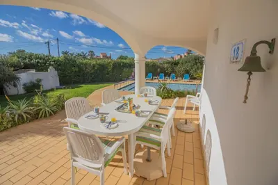 a white table and chairs on a patio at Casa dos Sonhos Praia da Luz in Luz
