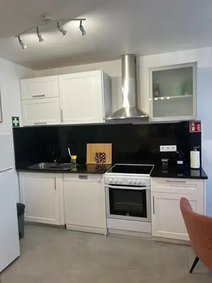 a kitchen with white cabinets and a stove top oven at Casa Bamboo central Funchal Villa in Funchal