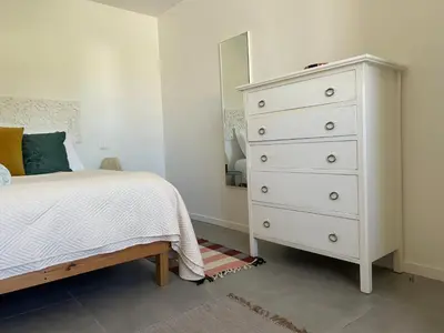 a bedroom with a bed and a dresser with a mirror at Casa Bamboo central Funchal Villa in Funchal