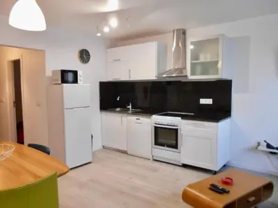 a kitchen with white appliances and a wooden table at Casa Bamboo central Funchal Villa in Funchal