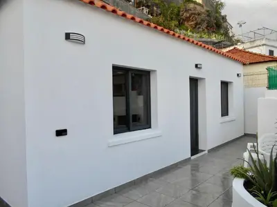 a white house with windows and a courtyard at Casa Bamboo central Funchal Villa in Funchal