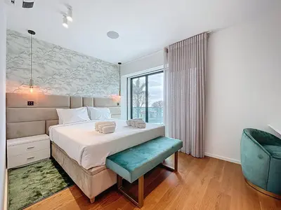 a bedroom with a large bed and a blue chair at Varinos Seaview Apartment in Funchal