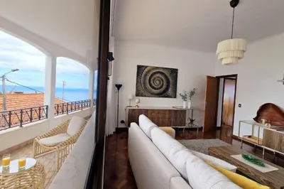 a living room with a couch and a table at Villa Branca in Ponta do Sol