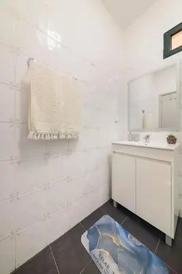 a white bathroom with a sink and a mirror at Casa do Vale by Mth in Ribeira Brava