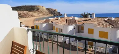 a balcony with a view of a beach and houses at Magnifique appartement face à l'océan, Casa Waterside in Luz