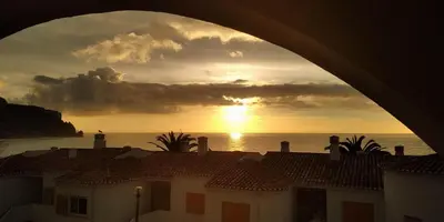 a view of the sunset from a building with roofs at Magnifique appartement face à l'océan, Casa Waterside in Luz