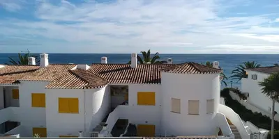 a white house with the ocean in the background at Magnifique appartement face à l'océan, Casa Waterside in Luz
