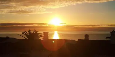 a sunset over the ocean with the sun in the sky at Magnifique appartement face à l'océan, Casa Waterside in Luz