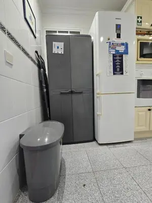 a kitchen with a refrigerator and a trash can at Paz House in Caniço