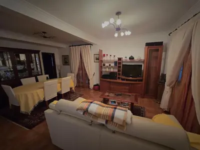 a living room with a couch and a table at Paz House in Caniço