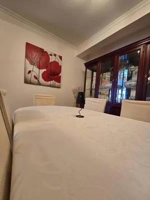a bedroom with a large white bed with two chairs at Paz House in Caniço