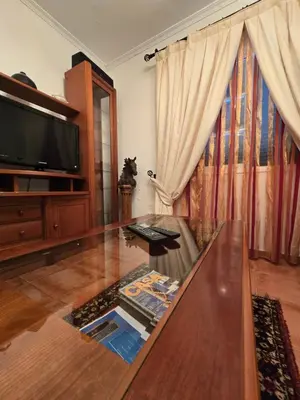 a living room with a glass table and a tv at Paz House in Caniço