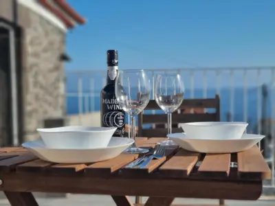 a patio with a table and chairs on a balcony at Social Lodge Galinho House - Sea View - Calheta in Estreito da Calheta