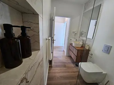 a bedroom with a large bed and a bathroom at Vila Ladeira dos Zimbreiros - 3 bedroom, Jacuzzi, gym, AC, Pool with optional heated water in Paul do Mar