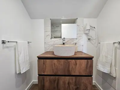 a bathroom with a sink and a mirror at Vila Ladeira dos Zimbreiros - 3 bedroom, Jacuzzi, gym, AC, Pool with optional heated water in Paul do Mar