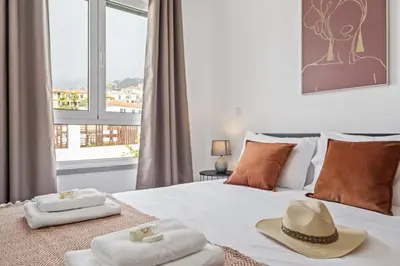 a bedroom with a bed with towels and hats on it at Locally by Homie in Funchal