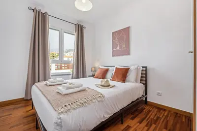 a bedroom with a large bed with a window at Locally by Homie in Funchal