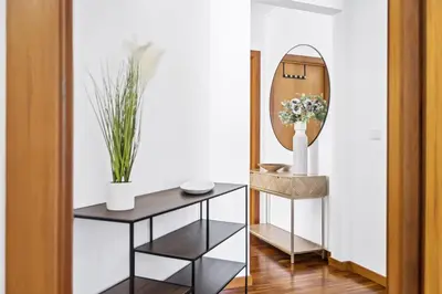 a hallway with a table and a mirror at Locally by Homie in Funchal