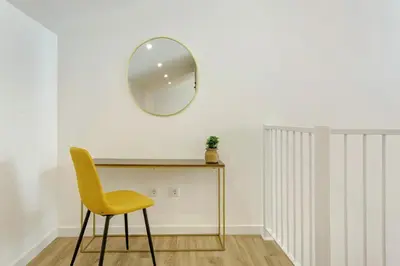 a table with a yellow chair and a mirror at Casa Belavista in Gaula